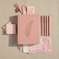 Flat lay of pink journal bundle including journal, pens, stickers, post-it notes, and bookmarks